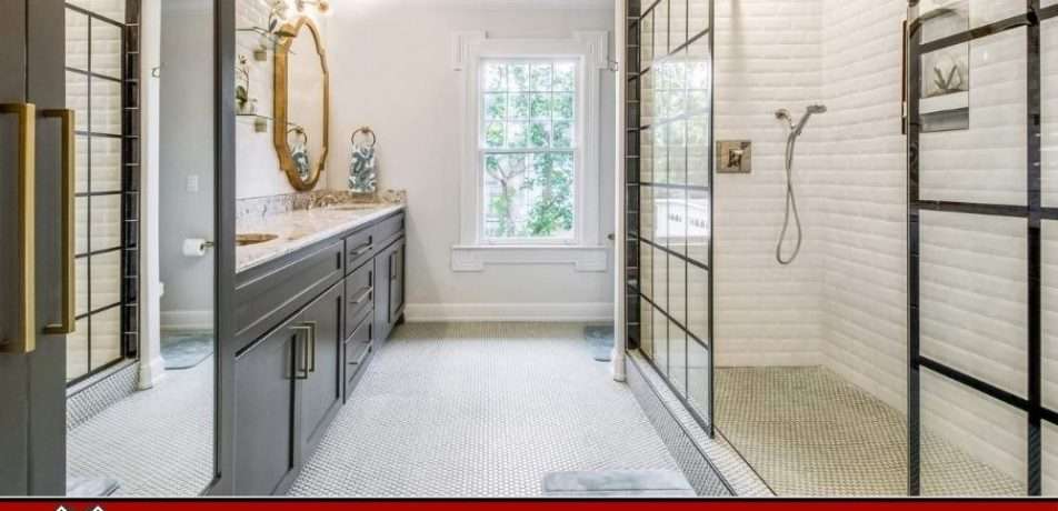 Elegant bathroom by Make Ready Home with black framed glass shower, gray vanity, and gold fixtures.