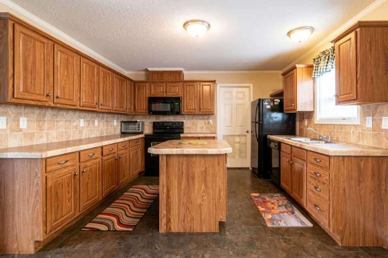 Make Ready Home cabinet painting or replacement in Dallas kitchen with classic wood cabinetry, tile backsplash, and black appliances.
